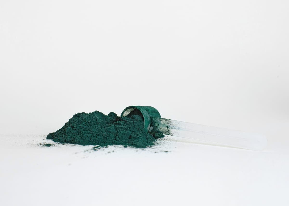Bright green powder photographed loose against a plain studio background.